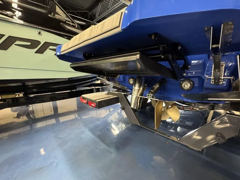 Slide: The Image of 2025 Supra SA 450 boat rear view, showcasing propeller and trim tabs in a showroom. - 8