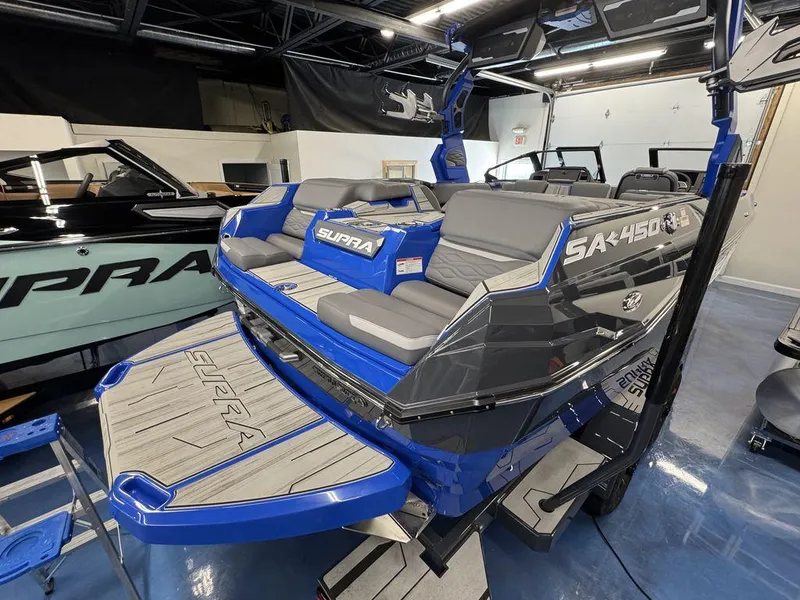 Slide: The Image of 2025 Supra SA 450 boat with sleek design and spacious seating in showroom. - 9