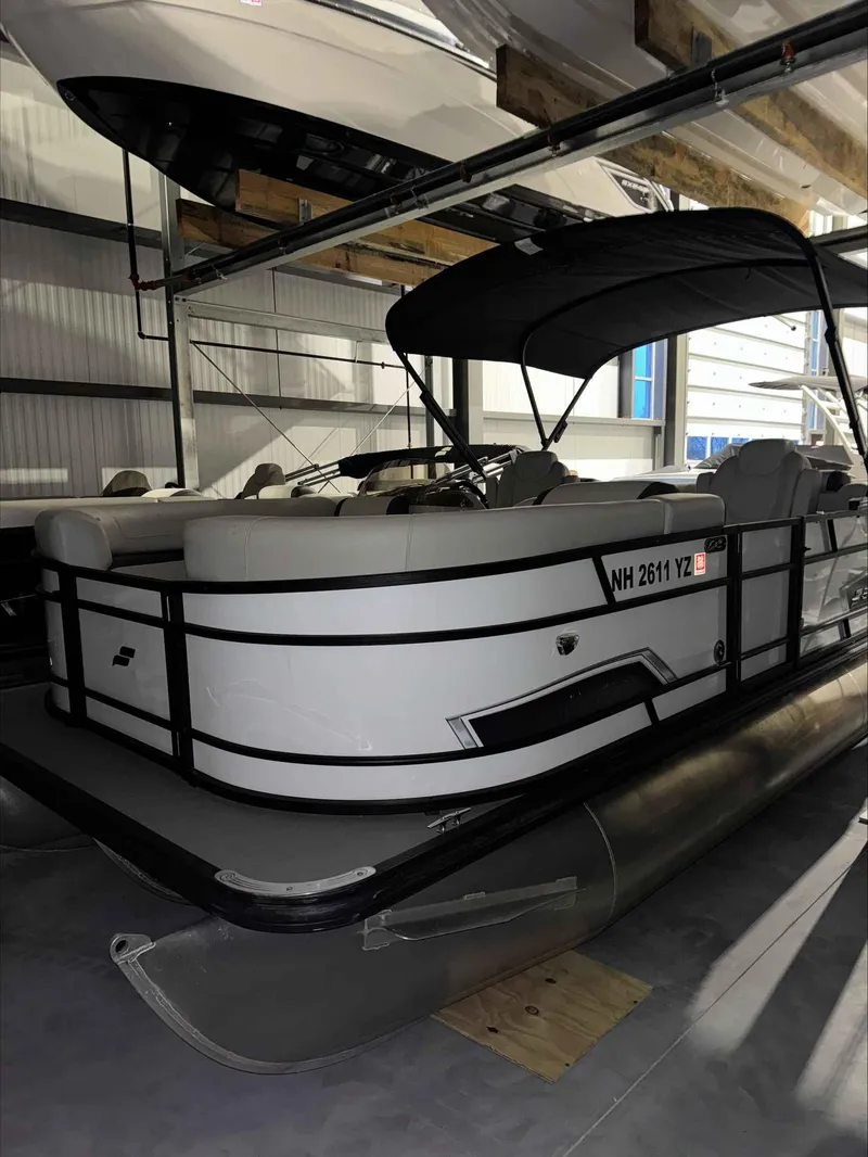 Slide: The Image of 2022 Starcraft EXS 3 pontoon boat in indoor storage facility. - 1