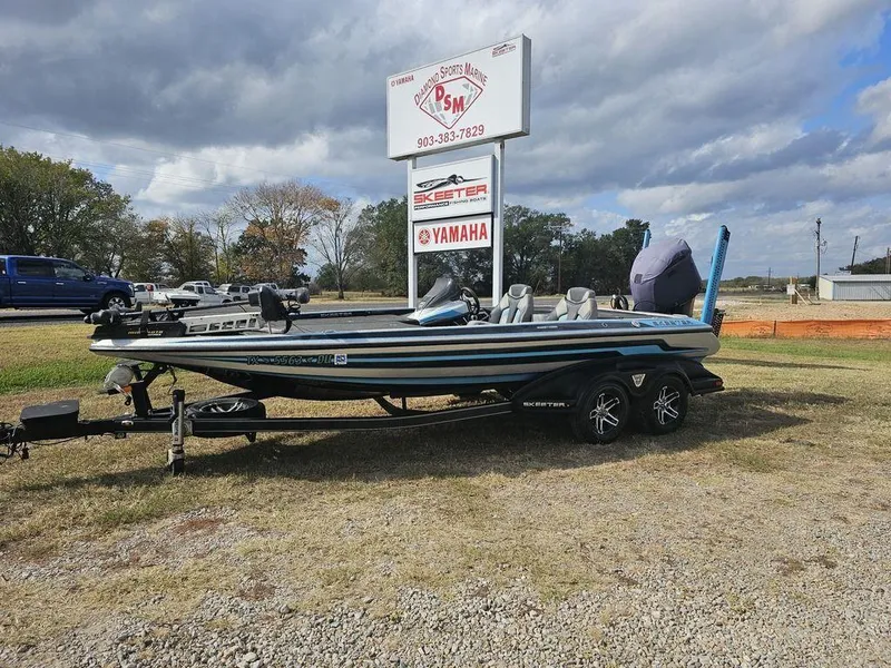 Slide: The Image of 2017 Skeeter FX20 LE bass boat on trailer, parked outdoors near dealership sign. - 1