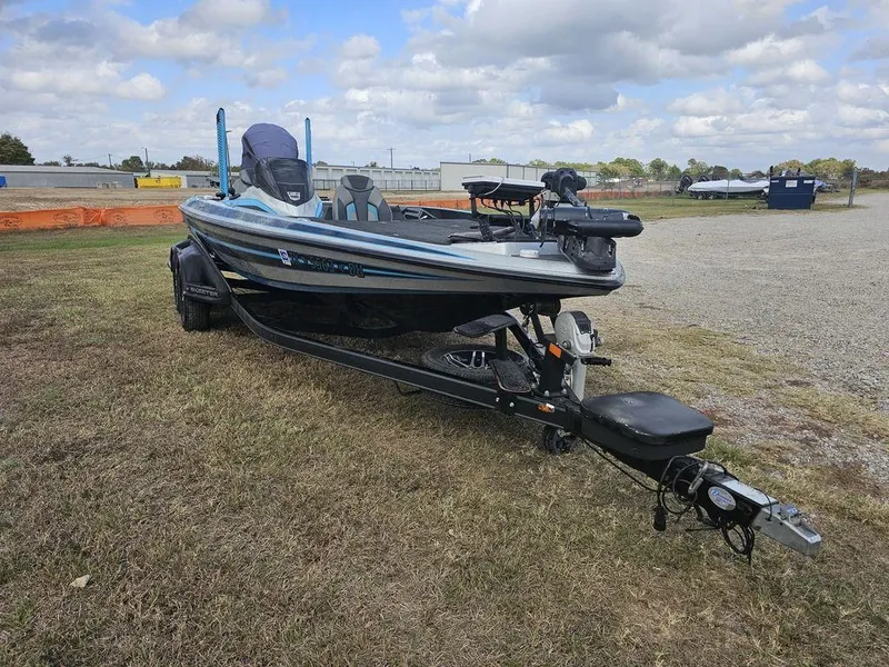 Slide: The Image of 2017 Skeeter FX20 LE bass boat on trailer, parked on grassy area under cloudy sky. - 12