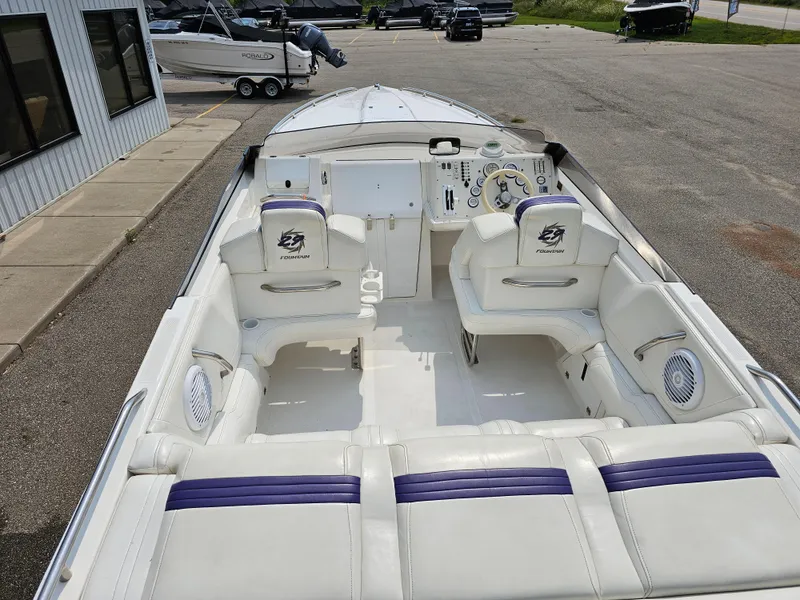 Slide: The Image of 1999 Fountain 29 Fever boat with white and purple interior, docked on pavement. - 6