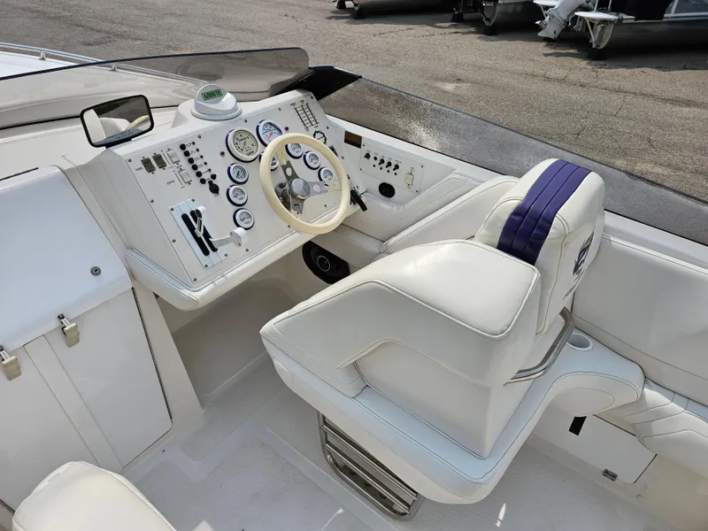 Slide: The Image of 1999 Fountain 29 Fever boat cockpit with white leather seating and control panel. - 9