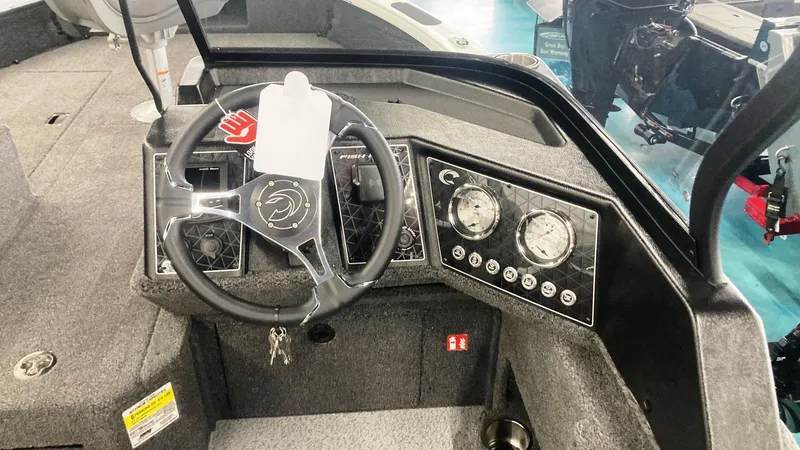 Slide: The Image of 2025 Crestliner 1850 Fish Hawk WT JS boat dashboard with steering wheel and gauges. - 3