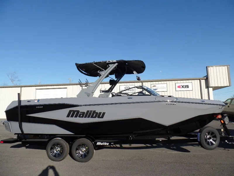 The Image of 2025 Malibu 25 LSV boat on trailer, sleek design, gray and black color scheme. - 1
