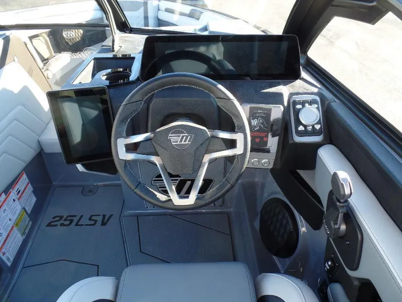 Slide: The Image of 2025 Malibu 25 LSV boat dashboard with modern steering and digital displays. - 14