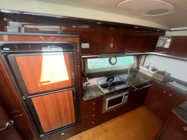 Slide: The Image of Luxurious kitchen interior of 2012 Sea Ray 500 Sundancer yacht with wood cabinetry. - 13