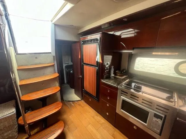 Slide: The Image of Interior of 2012 Sea Ray 500 Sundancer yacht with modern kitchen and wooden stairs. - 14
