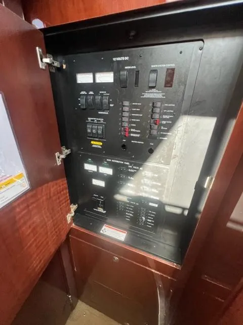 Slide: The Image of Electrical panel inside 2012 Sea Ray 500 Sundancer yacht, showcasing circuit breakers and controls. - 15