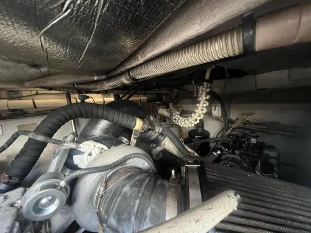 Slide: The Image of Engine compartment of 2012 Sea Ray 500 Sundancer boat, showing hoses and mechanical components. - 26