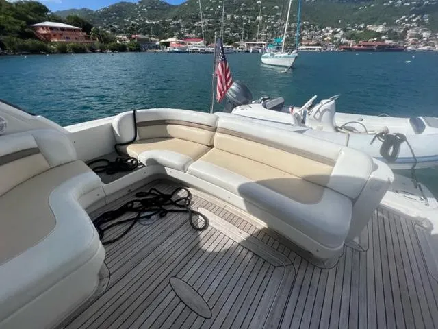 Slide: The Image of 2012 Sea Ray 500 Sundancer yacht with spacious deck seating, docked in scenic harbor. - 6