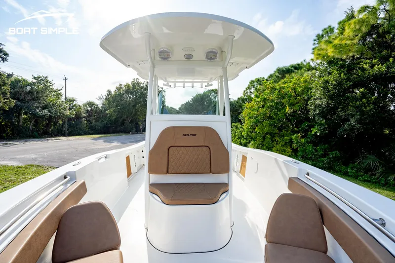 Slide: The Image of 2024 Sea Pro 239 Deep V CC boat interior with seating and console, surrounded by greenery. - 15