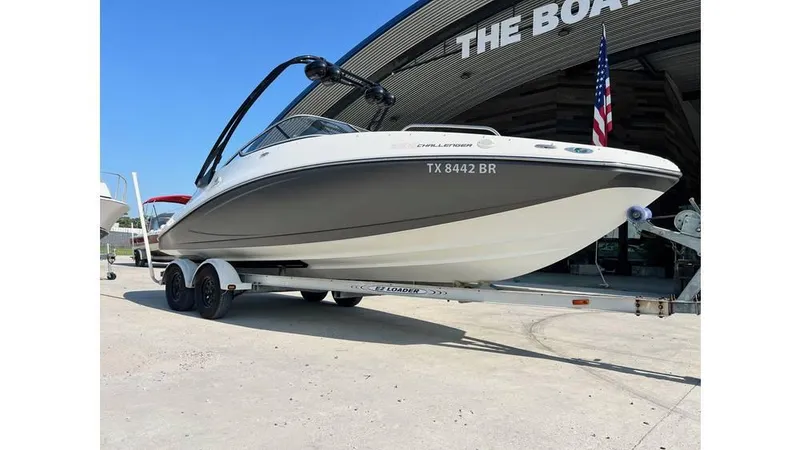 Slide: The Image of 2012 Sea-Doo 230 Challenger SE boat on trailer, parked outside dealership. - 2