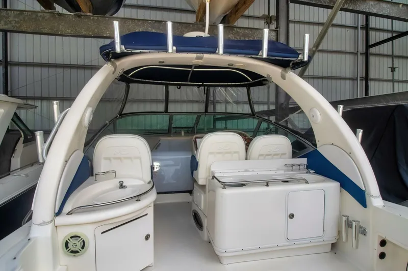 Slide: The Image of 2005 Sea Ray 340 Sundancer interior with seating and storage in a marina setting. - 5