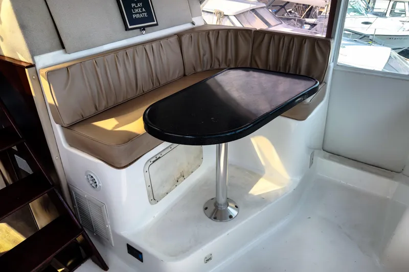 Slide: The Image of Interior of 2001 Sandpiper 50 boat with cushioned seating and table. - 13