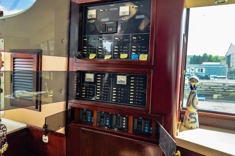Slide: The Image of Electrical control panel inside a 2001 Sandpiper 50 boat, featuring gauges and switches. - 18
