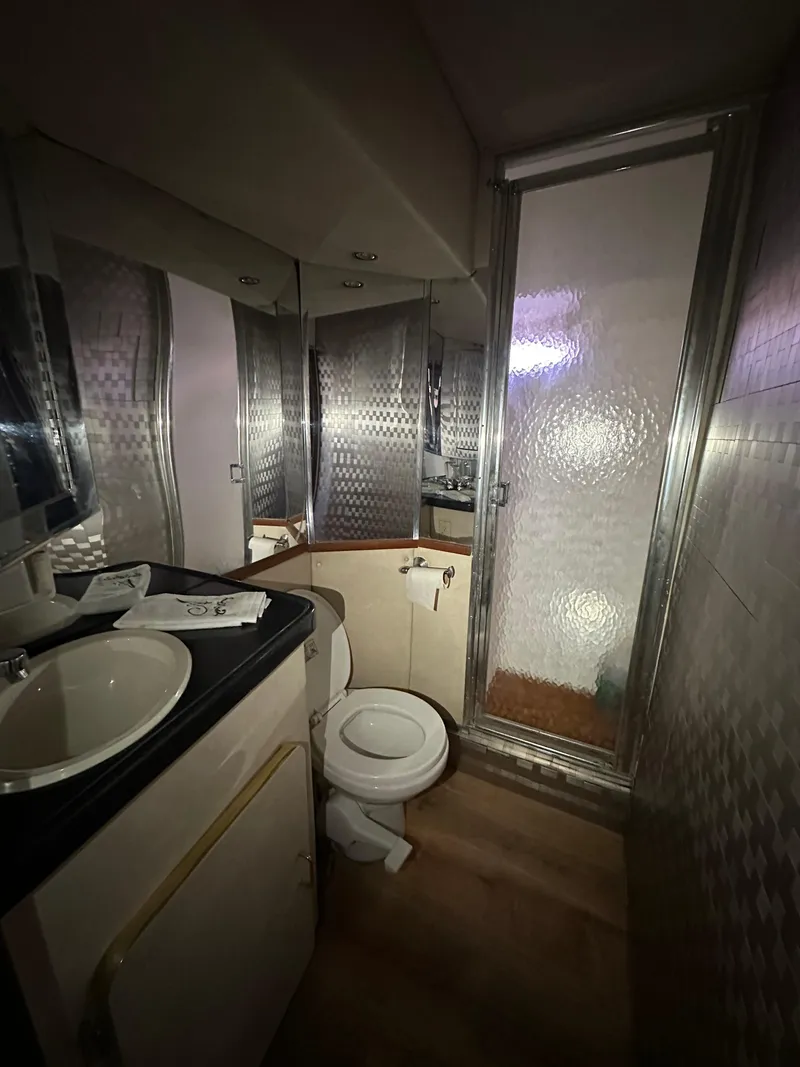 Slide: The Image of Compact bathroom in a 2001 Sandpiper 50, featuring a toilet, sink, and shower. - 20