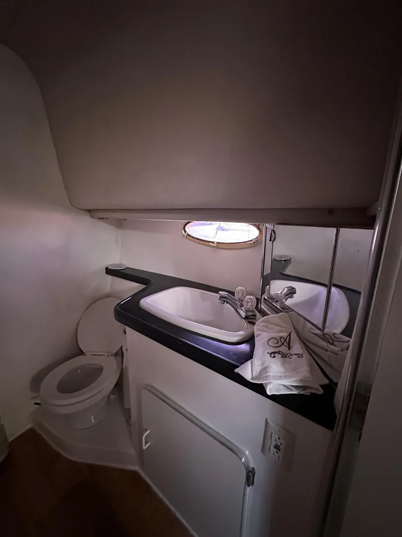 Slide: The Image of Compact bathroom in 2001 Sandpiper 50 boat with sink, toilet, and porthole. - 24