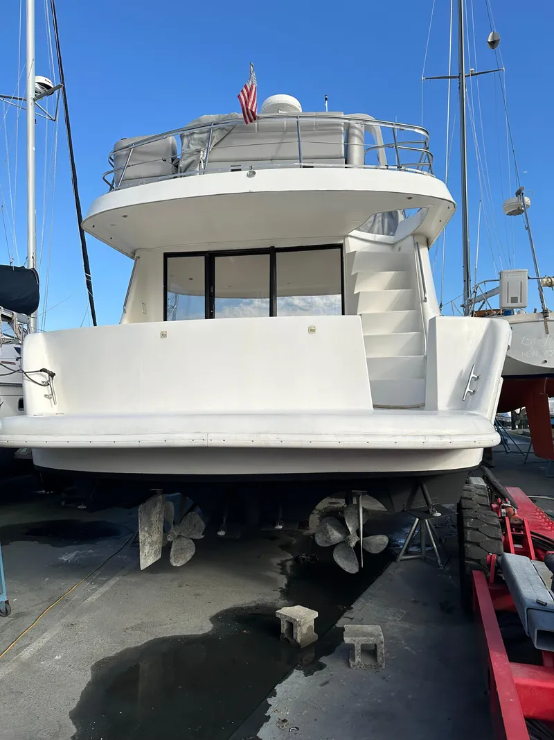 Slide: The Image of 2001 Sandpiper 50 yacht on dry dock, rear view with visible propellers and stairs. - 33