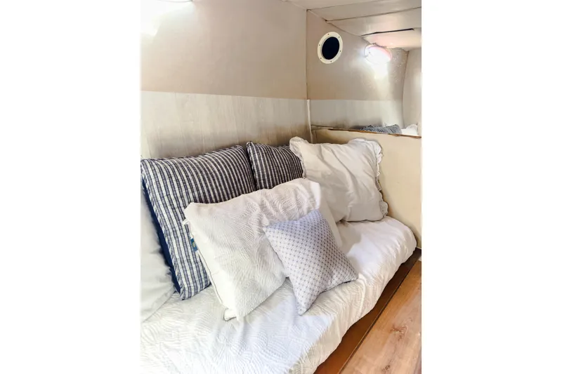 Slide: The Image of Cozy interior of 2001 Sandpiper 50 with striped and white pillows on a cushioned bench. - 4