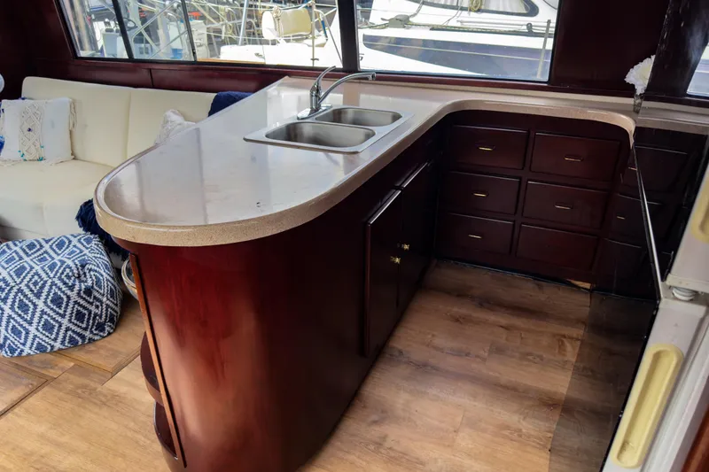 Slide: The Image of Luxurious yacht kitchen with wooden cabinets, dual sink, and cozy seating area. Sandpiper 50, 2001 model. - 6