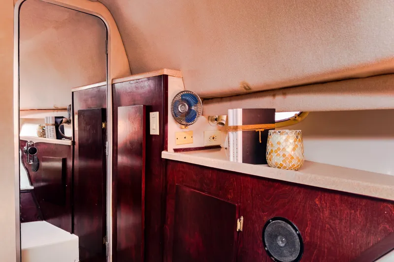 Slide: The Image of Interior of 2001 Sandpiper 50 boat with wooden cabinets and decorative items. - 7