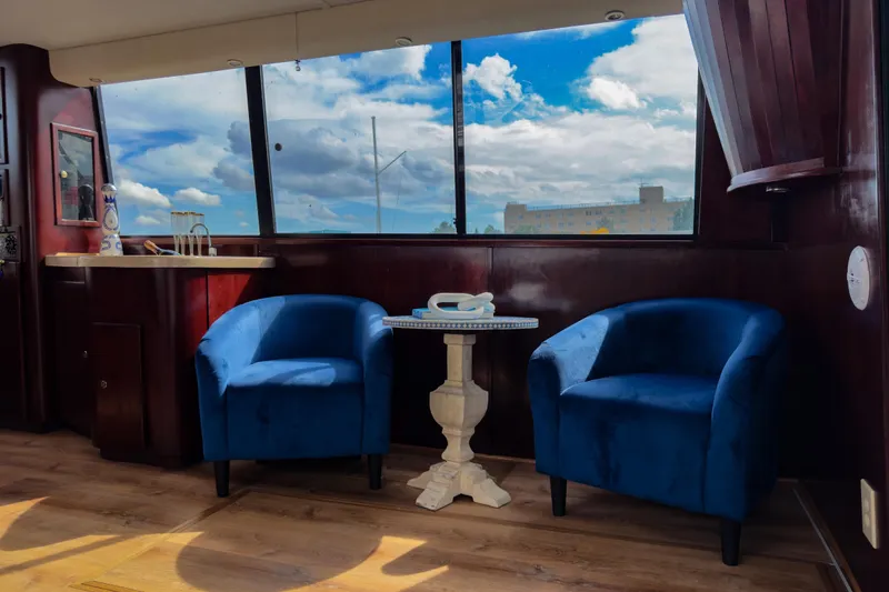 Slide: The Image of Interior of 2001 Sandpiper 50 with blue chairs, table, and large window view. - 8