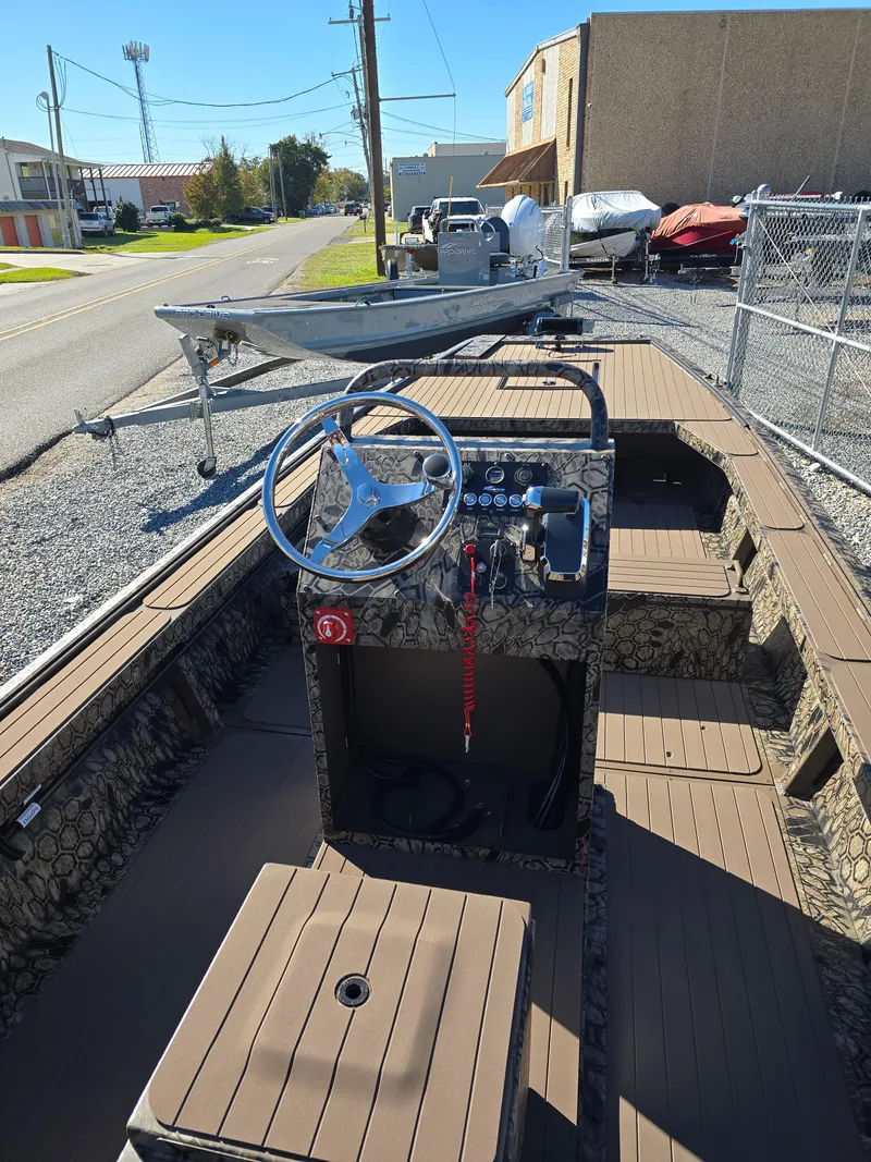 Slide: The Image of 2024 Pro-Drive X Series 1860 CC boat with camouflage interior, parked outdoors. - 13