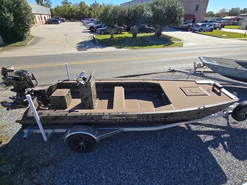 Slide: The Image of 2024 Pro-Drive X Series 1860 CC boat on trailer, parked outdoors. - 14