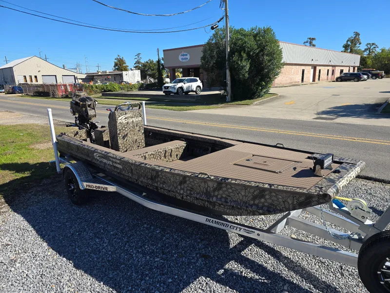 Slide: The Image of 2024 Pro-Drive X Series 1860 CC boat on trailer, camo design, parked outdoors. - 15