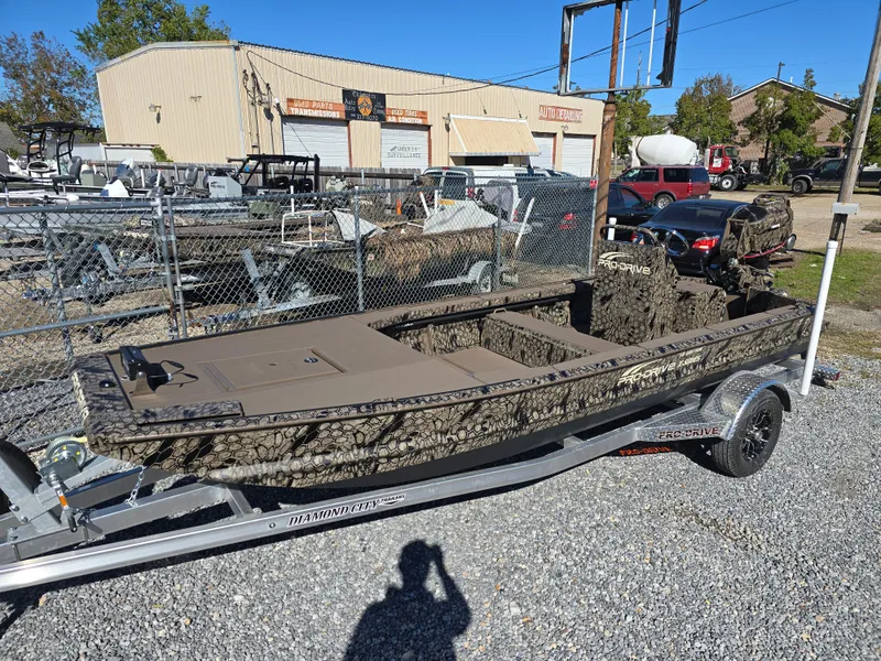 Slide: The Image of 2024 Pro-Drive X Series 1860 CC boat on trailer, camouflage design, parked outdoors. - 3