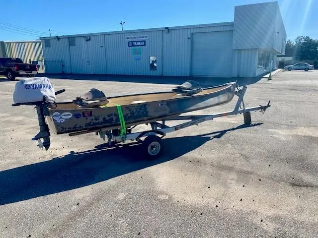 Slide: The Image of 1999 Gheenoe 13' boat on trailer with Yamaha motor in parking lot. - 4