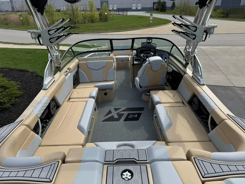 Slide: The Image of 2024 MasterCraft XT24 boat interior with beige seating and modern dashboard. - 13