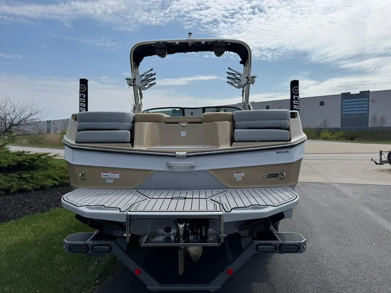 Slide: The Image of 2024 MasterCraft XT24 boat rear view with swim platform and wakeboard racks. - 6