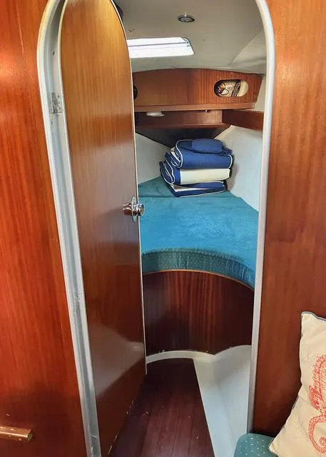 Slide: The Image of Cozy cabin interior of 1990 Beneteau Sloop with wooden door and blue bedding. - 14