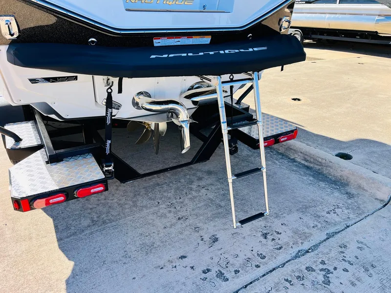 Slide: The Image of 2025 Nautique Super Air Nautique G25 Paragon boat with ladder and trailer. - 11