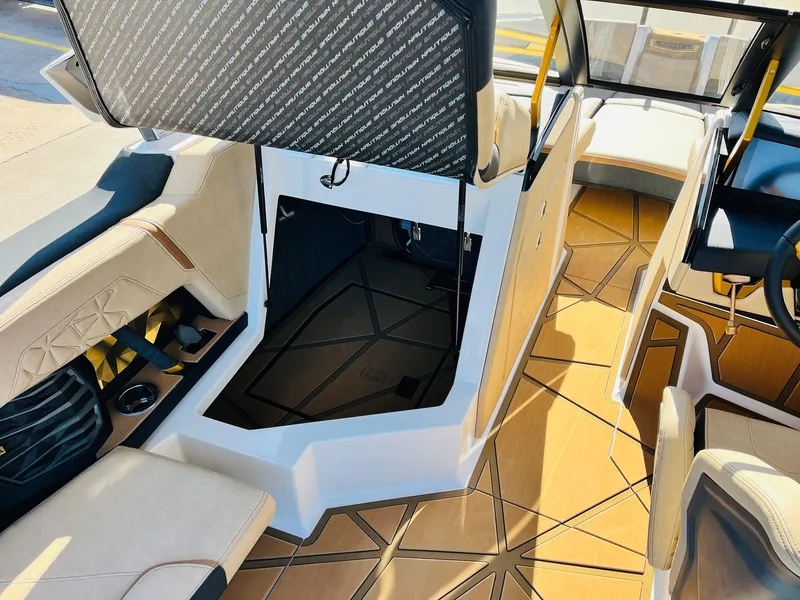 Slide: The Image of Interior of 2025 Nautique Super Air Nautique G25 Paragon boat, featuring luxurious seating and flooring. - 38