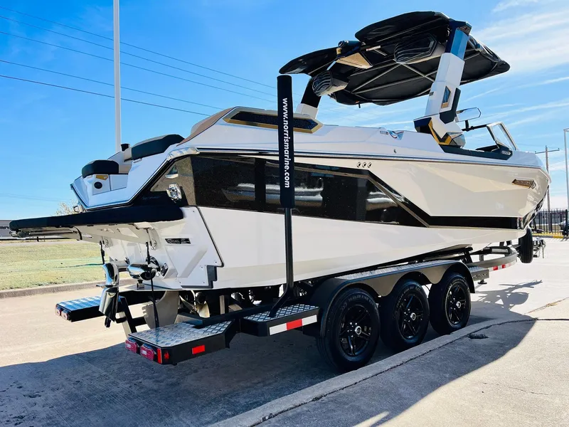 Slide: The Image of 2025 Nautique Super Air Nautique G25 Paragon boat on trailer, sleek design, sunny day. - 7