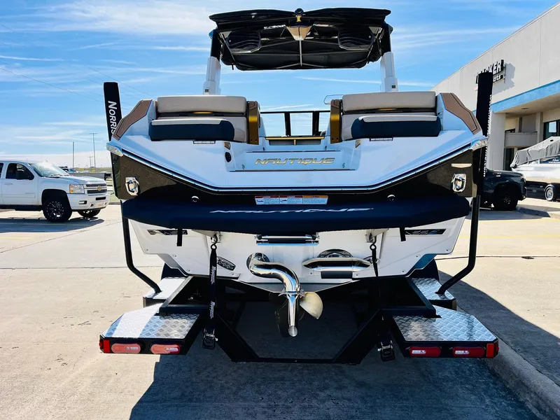 Slide: The Image of 2025 Nautique Super Air Nautique G25 Paragon boat, rear view, parked outdoors. - 8