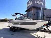 Slide: The Image of 2024 MasterCraft XT25 boat on trailer outside dealership. - 1