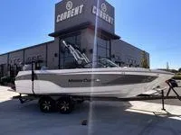 Slide: The Image of 2024 MasterCraft XT25 boat on trailer outside dealership. - 2