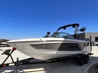 Slide: The Image of 2024 MasterCraft XT25 boat on trailer under clear blue sky. - 4