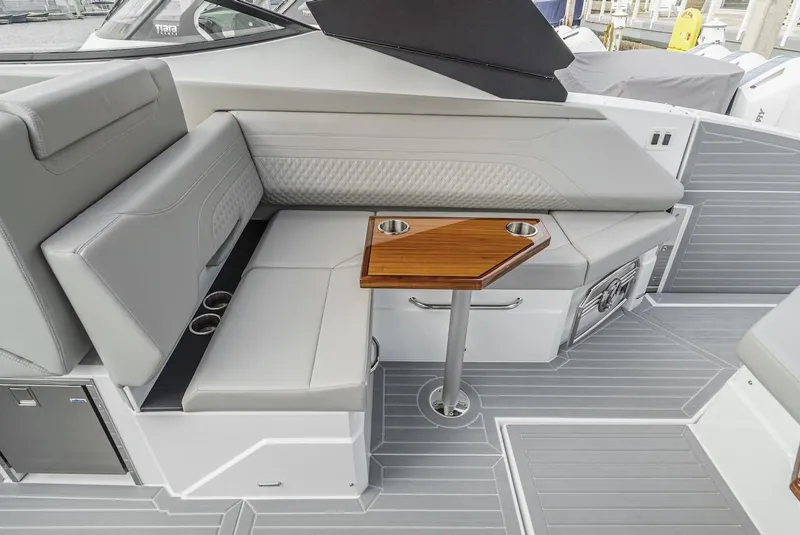 Slide: The Image of 2024 Cruisers Yachts 38 GLS OB interior with sleek seating and wooden table. - 34