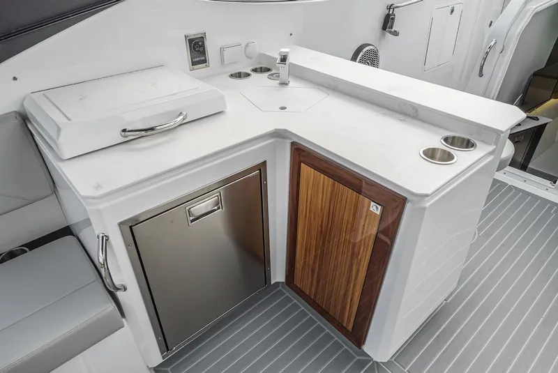 Slide: The Image of 2024 Cruisers Yachts 38 GLS OB boat kitchenette with sink, storage, and stainless steel appliances. - 37