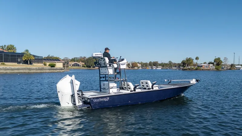 Slide: The Image of 2022 Young Boats 24 navigating a calm lake under clear blue skies. - 0