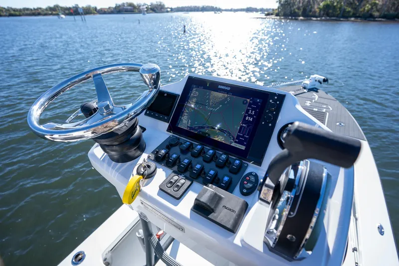 Slide: The Image of Young Boats 24, 2022 model, steering console with navigation system on a sunny lake. - 23