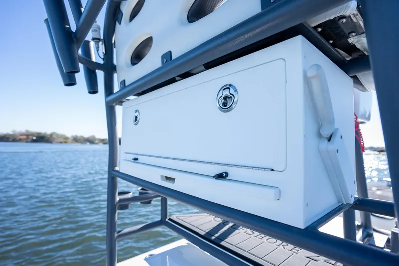 Slide: The Image of 2022 Young Boats 24 storage compartment on a boat with water in the background. - 25