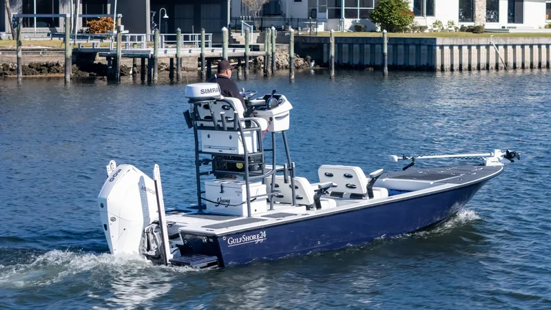 Slide: The Image of 2022 Young Boats 24 model cruising on a calm waterfront near docks. - 31