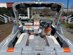 Slide: The Image of 2024 MasterCraft X22 boat interior with orange and gray seating, modern dashboard, and spacious layout. - 10