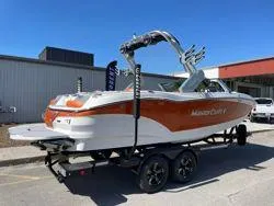 Slide: The Image of 2024 MasterCraft X22 boat on trailer, displayed outdoors near a dealership. - 3